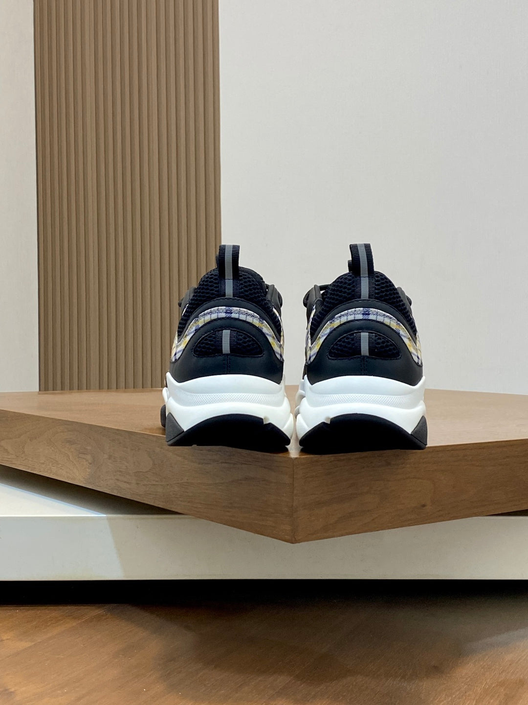 Back view of navy Dior sneakers with chunky white soles and heel pull tabs