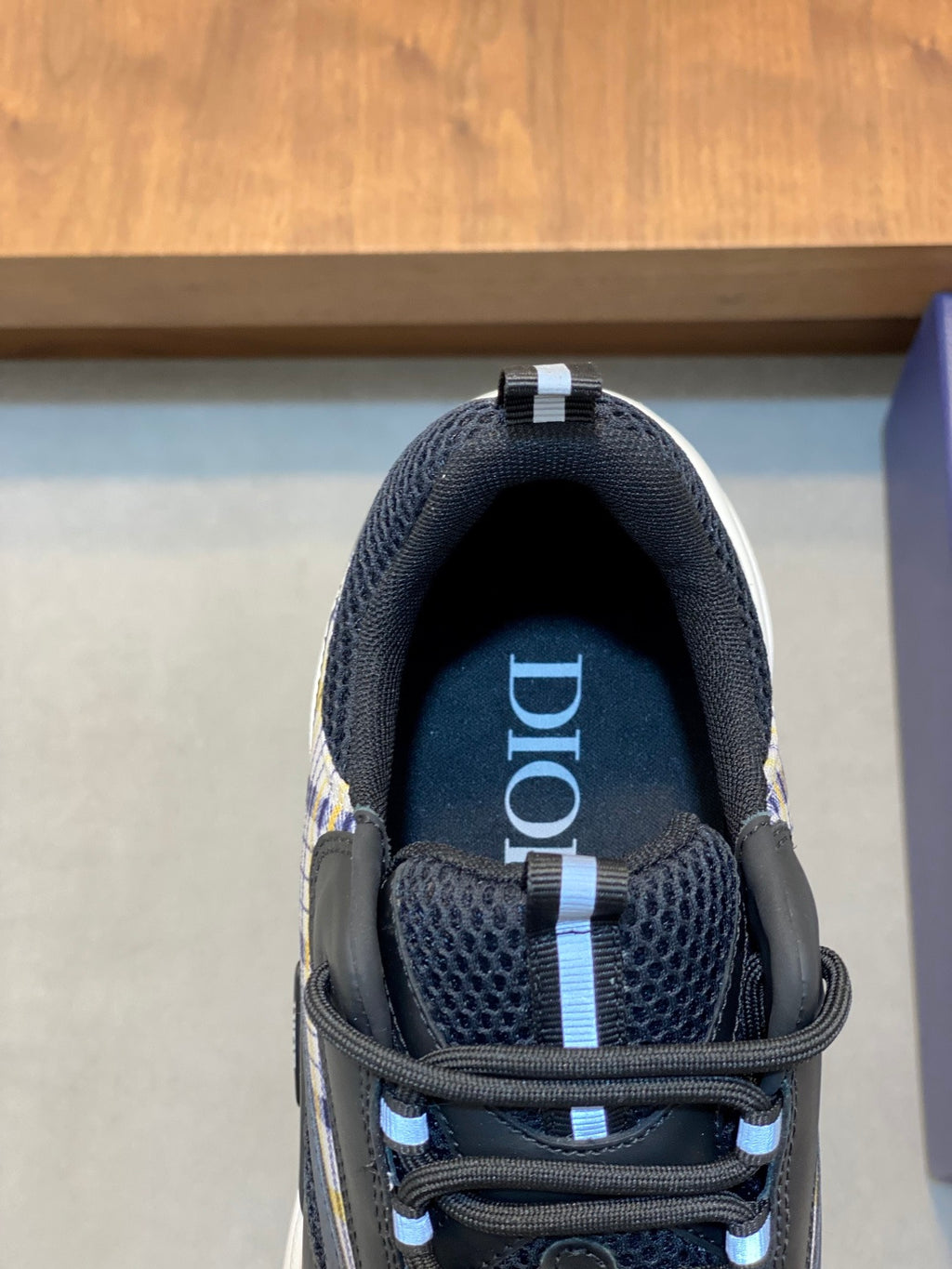 Dior logo on navy mesh tongue of lace-up sneaker, close-up view
