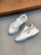 Pair of white low-top sneakers with light blue accents and cushioned thick sole