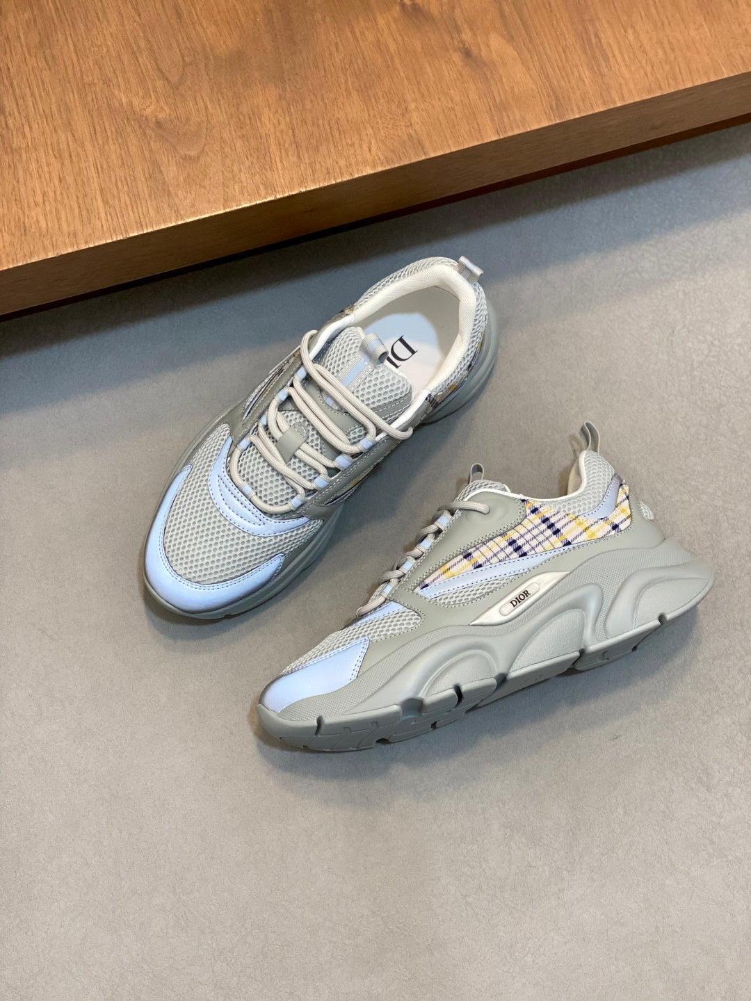 Pair of light blue mesh sneakers with blue plaid laces and thick tread sole