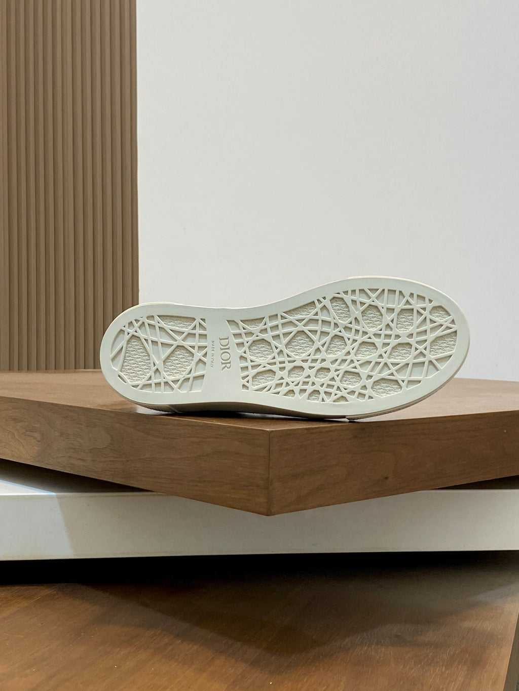 White sneaker outsole with geometric tread pattern, rubber sole.