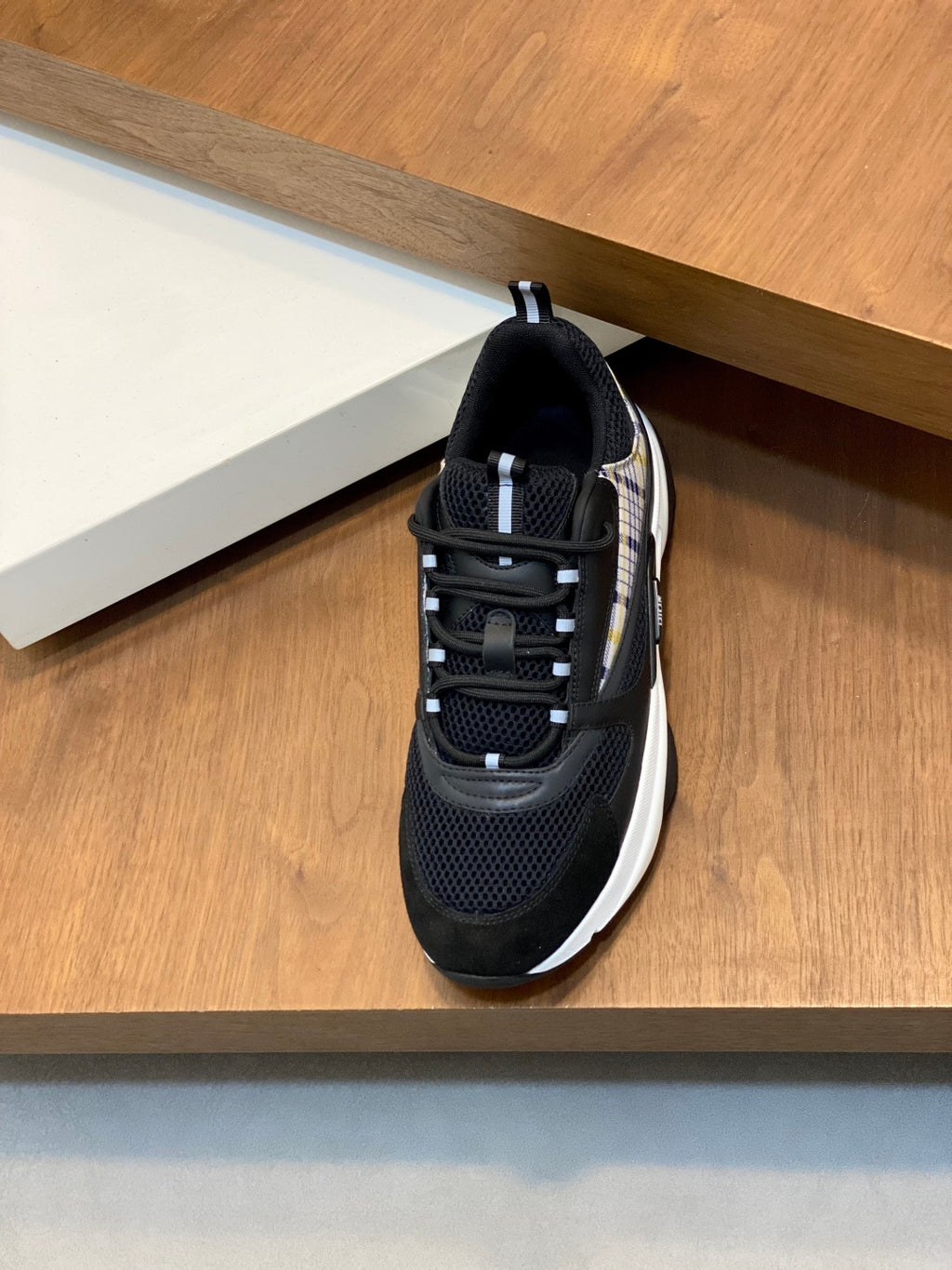 Black mesh Dior sneaker with lace-up front and chunky white sole edge, side view