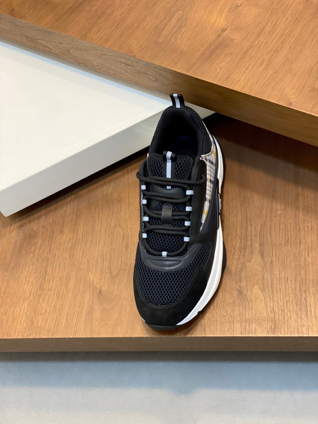 Black mesh Dior sneaker with lace-up front and chunky white sole edge, side view