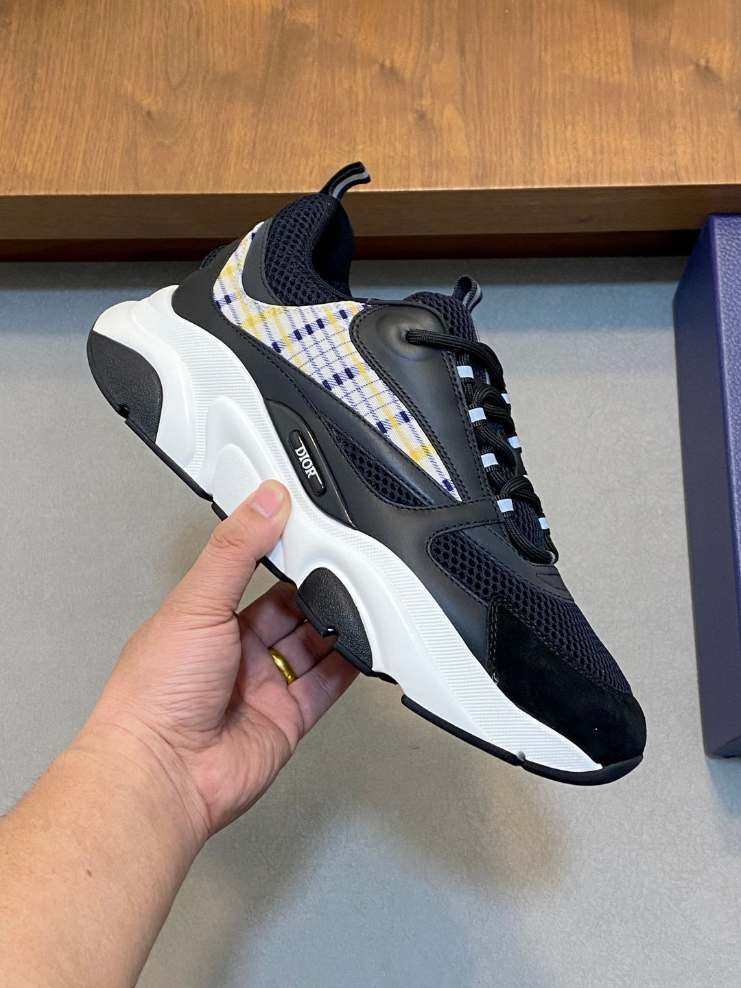 Navy lace-up sneaker with plaid strap detail and thick white sole, side close-up