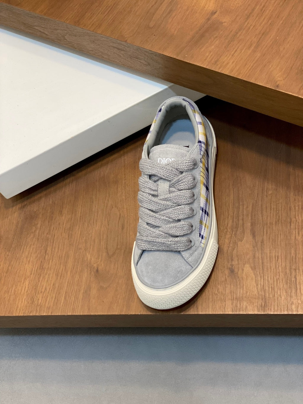 Grey low-top lace sneaker with blue-yellow plaid collar trim and white sole