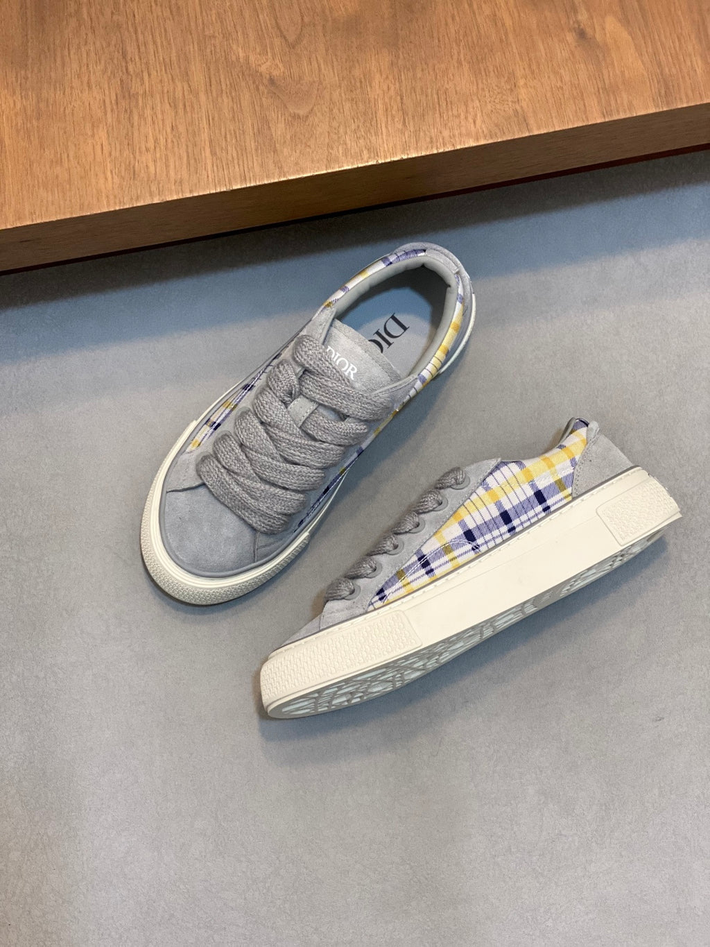 Grey low-top Dior sneakers with blue-yellow plaid detail on side