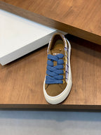 Single low-top sneaker on display with blue laces, plaid sides, and white rubber sole.