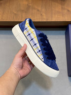 Navy blue sneaker with plaid stripe on quarter and white textured rubber sole.