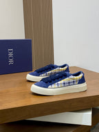 Navy blue lace-up sneakers with white and yellow plaid side detail, viewed from side.