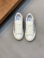 White low-top sneakers with blue plaid lining and fabric upper, lace-up.