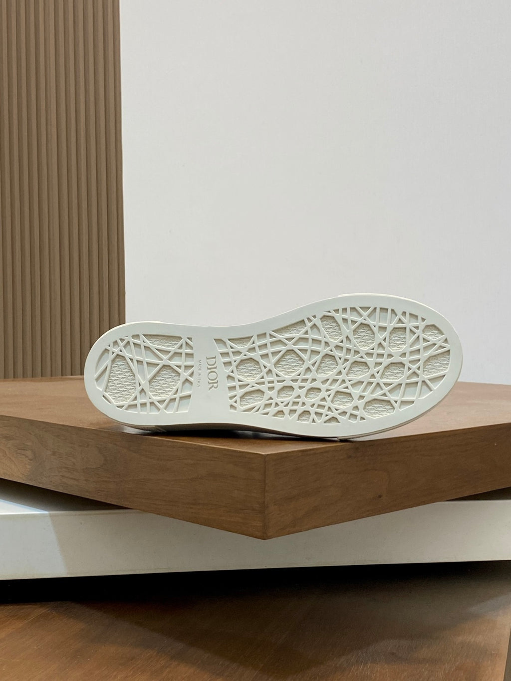 White outsole of lace-up sneakers with textured tread pattern.