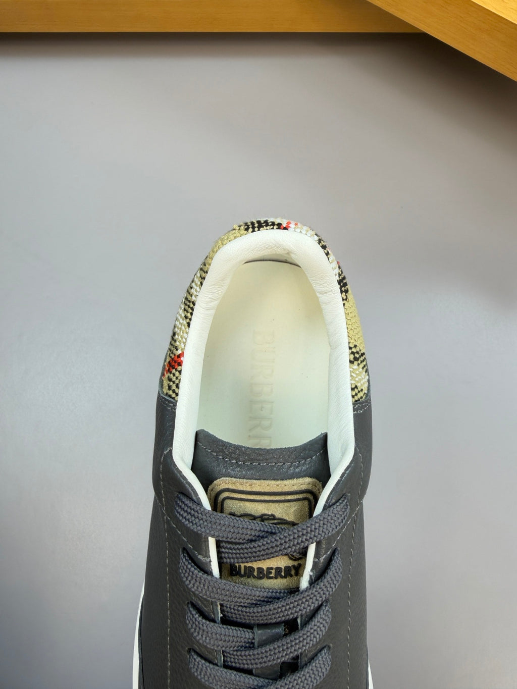 Dark navy sneakers with patterned collar lining and BURBERRY logo on the tongue