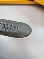 Close-up of dark leather sneaker upper with gray laces and white edge sole