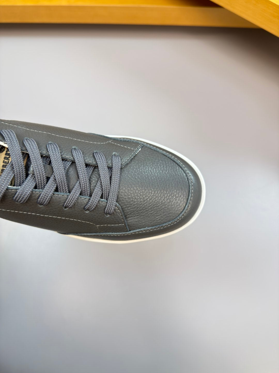 Close-up of dark leather sneaker upper with gray laces and white edge sole