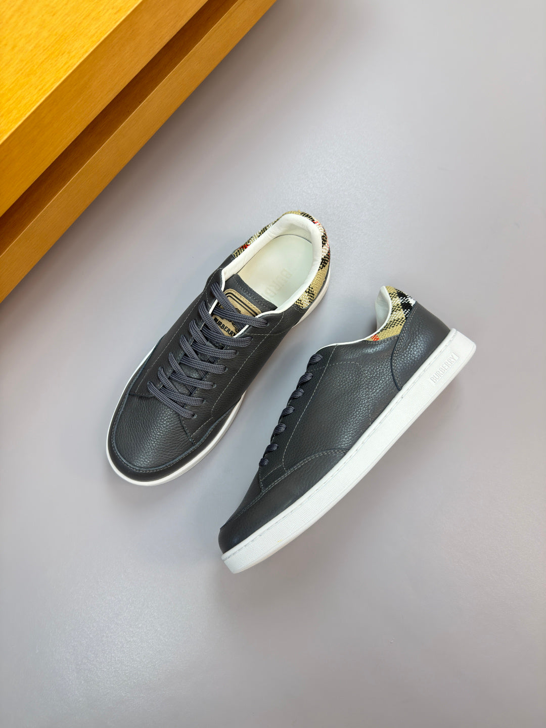 Dark navy lace-up sneakers with white sole and patterned lining at the collar