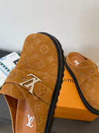 Louis Vuitton monogram sandal side view, tan strap with silver buckle on black edge