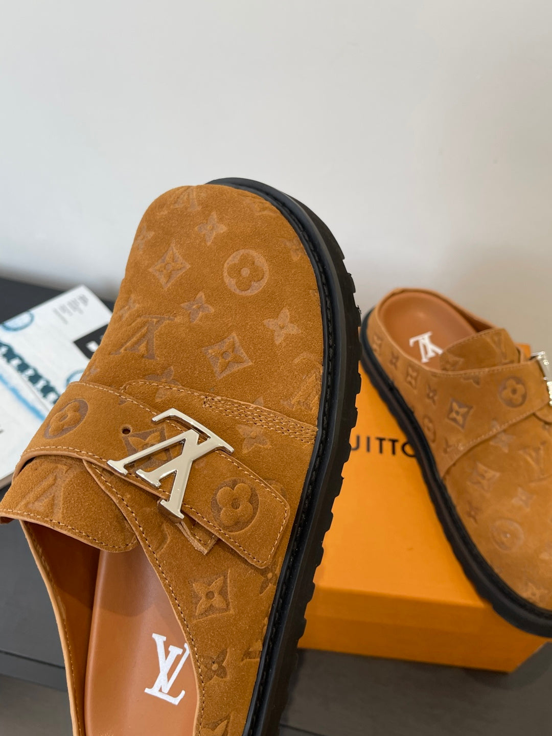 Louis Vuitton monogram sandal side view, tan strap with silver buckle on black edge
