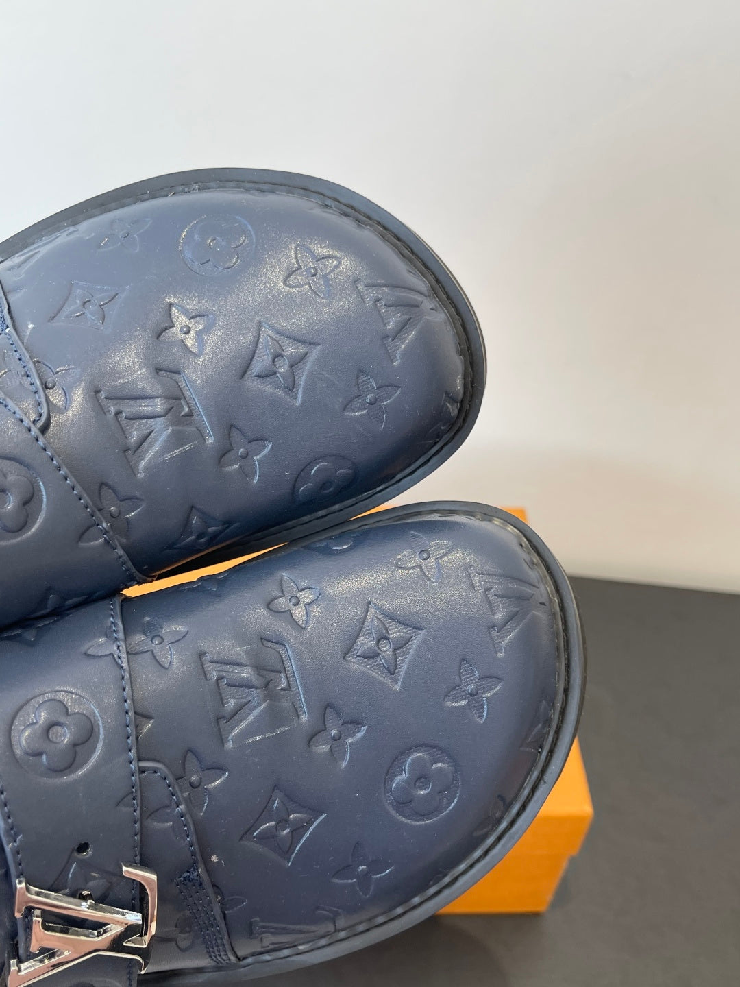 Louis Vuitton navy embossed slide sandal close-up of textured pattern and logo