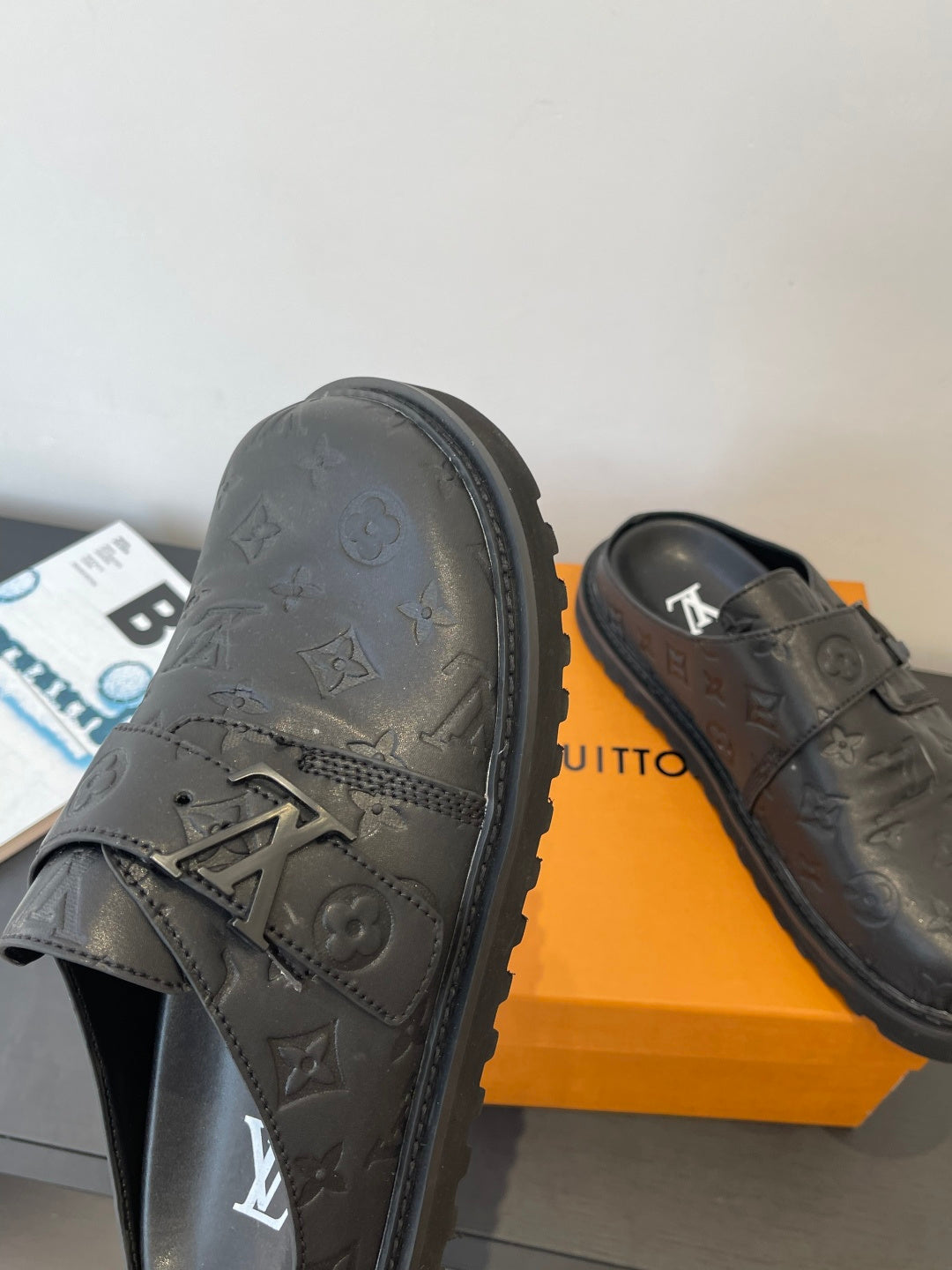 Louis Vuitton leather slide sandals with embossed monogram and buckle strap