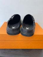 Louis Vuitton slide sandals with dark leather straps and embossed LV logo
