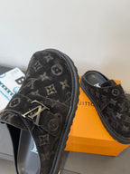 Louis Vuitton black monogram slide sandals, angled view with strap buckle