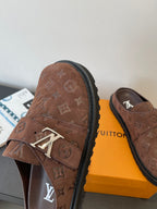 Brown monogram slip-on sandals with metal buckle detail and thick rubber sole