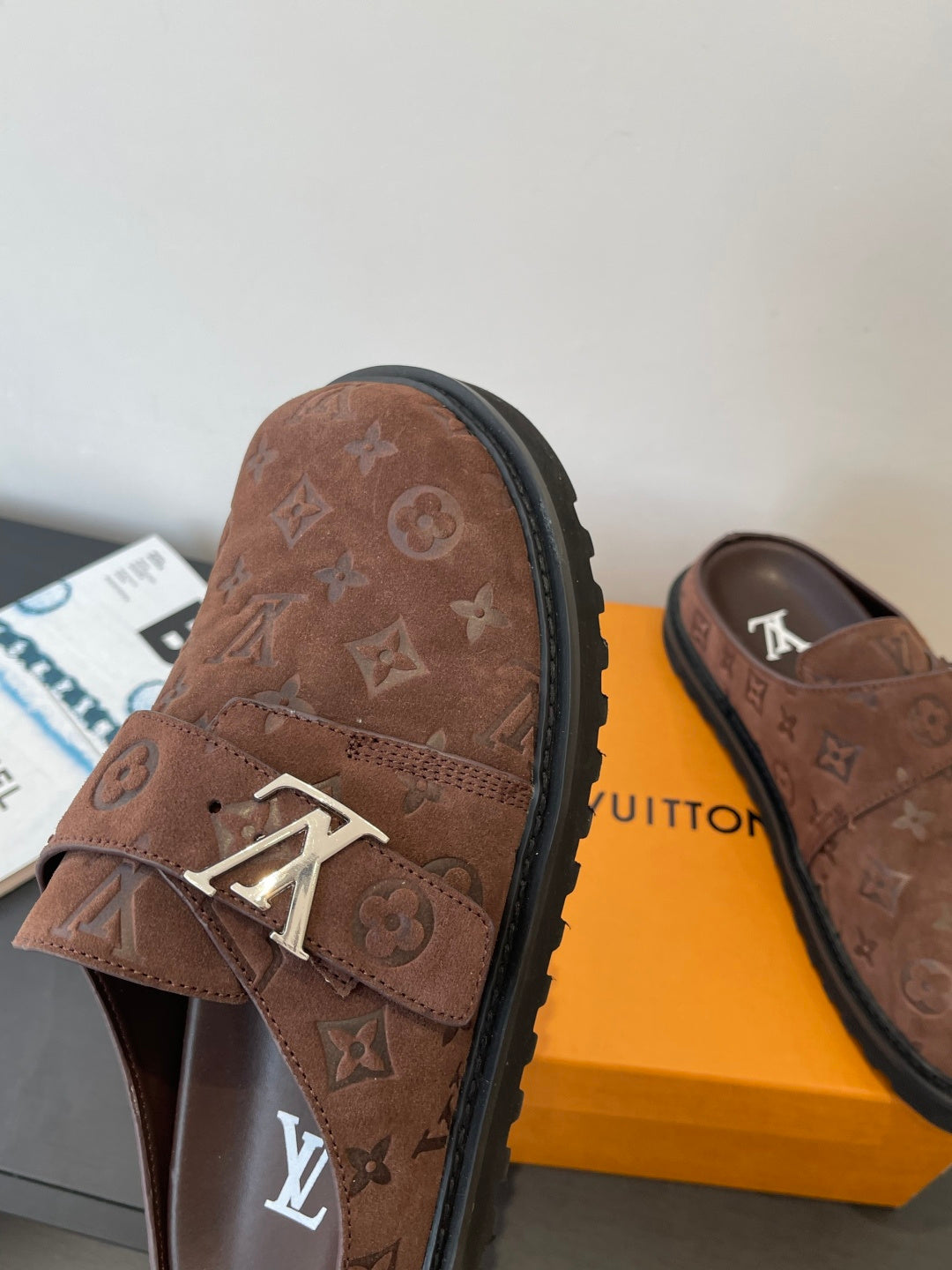 Brown monogram slip-on sandals with metal buckle detail and thick rubber sole