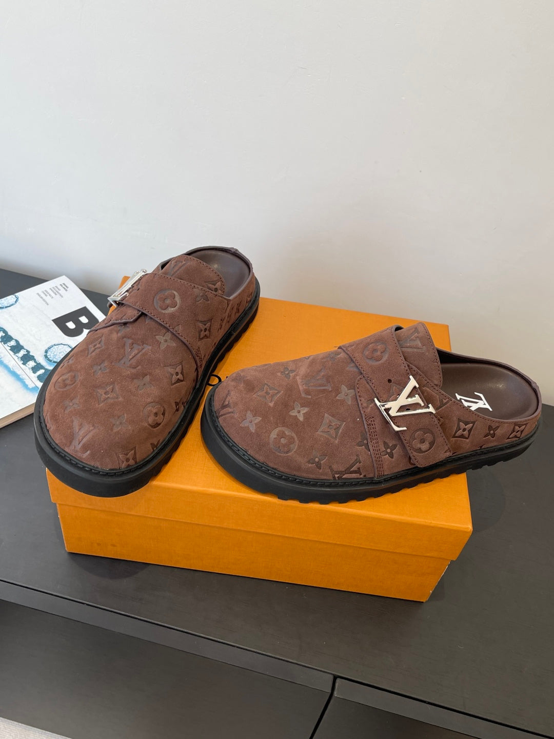 Brown monogram slip-on sandals with adjustable strap and dark rubber sole, side angle