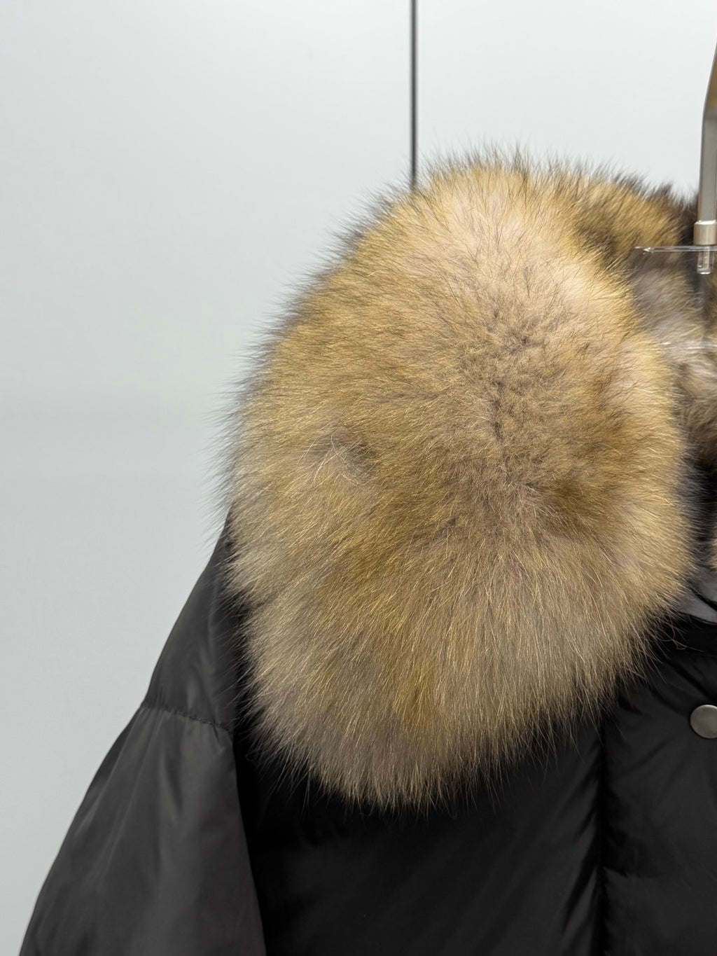 Tan fur collar on black puffer jacket with buttoned front placket