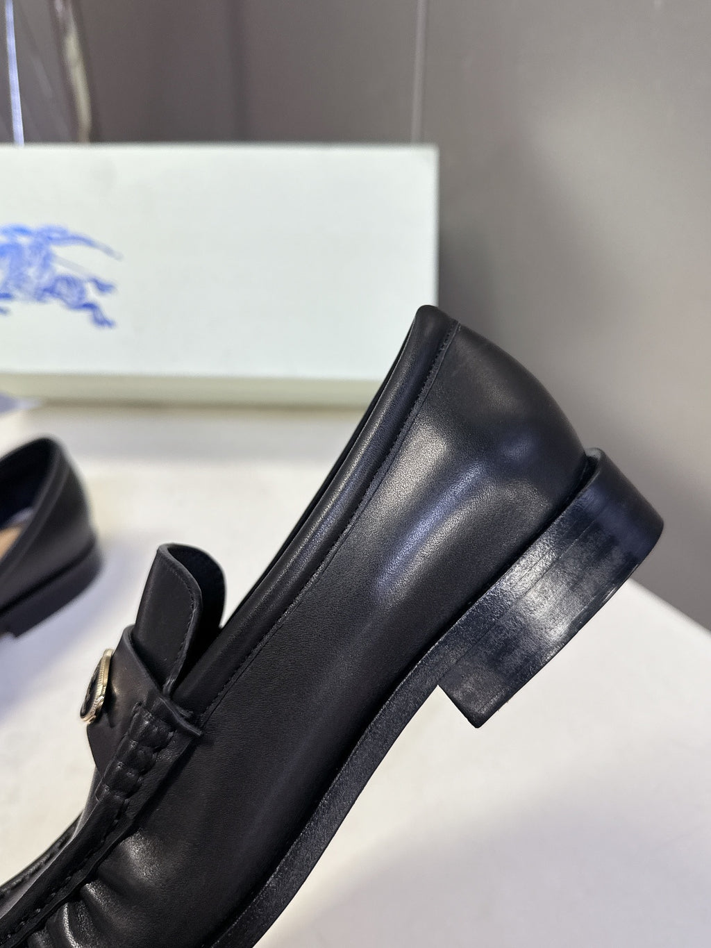 Burberry black leather loafer detail with logo hardware and side seam stitching