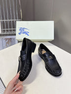 Burberry black leather loafers shown as a pair with gold logo accent