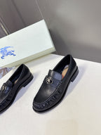 Burberry black leather loafers, front pair view with gold emblem on strap