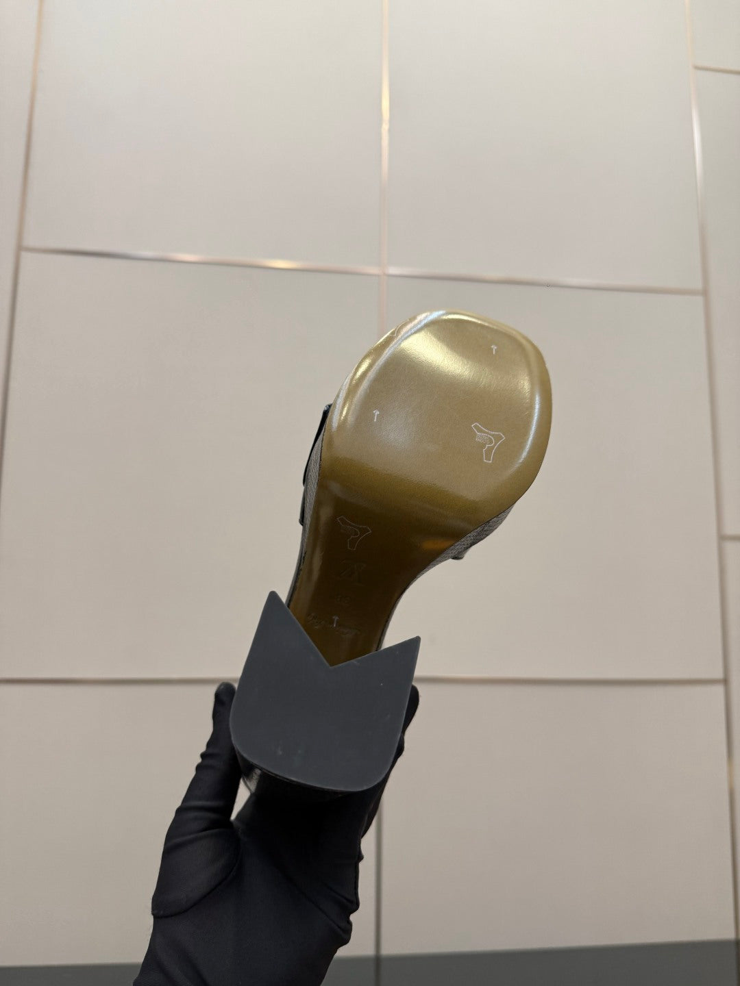 Black shoe heel sole with gold-toned underside