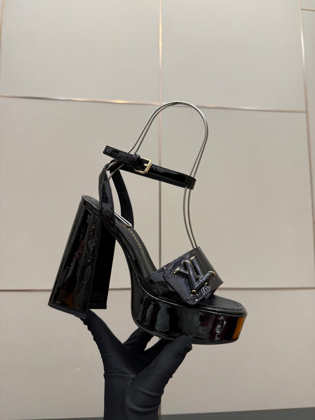 Black patent heeled sandal with ankle strap, open toe and tall heel