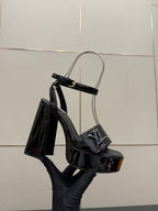 Black patent heeled sandal with ankle strap, open toe and tall heel
