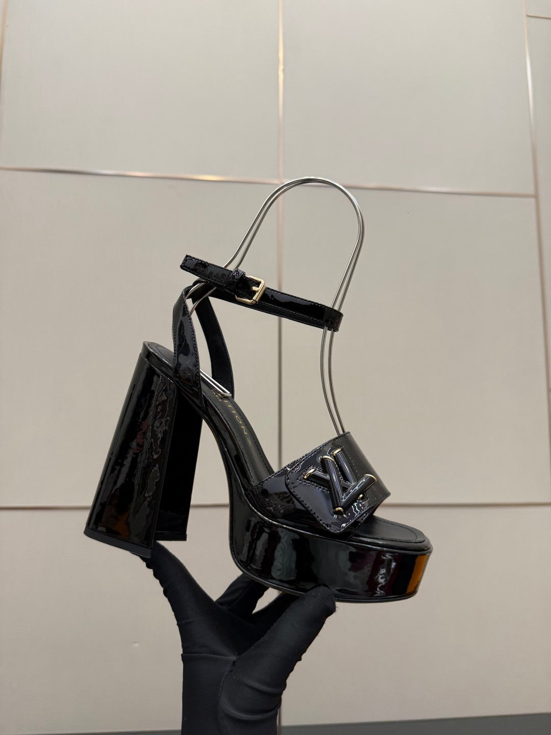 Black patent heeled sandal with ankle strap, open toe and tall heel