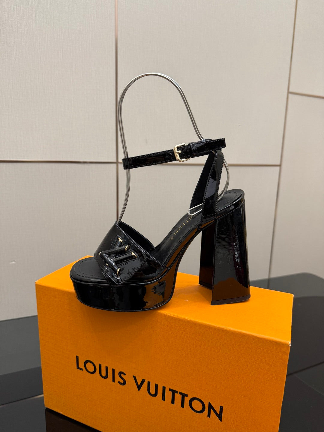 Black glossy heeled sandals with ankle strap and gold-tone buckle