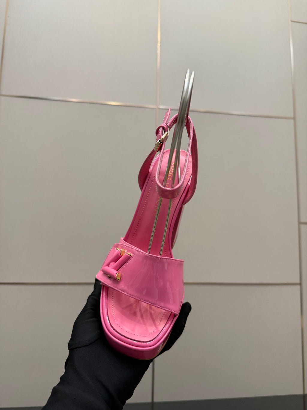 Women’s pink platform heeled sandals held upright, showing strap and sole profile