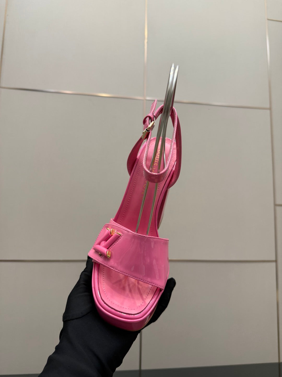 Women’s pink platform heeled sandals held upright, showing strap and sole profile