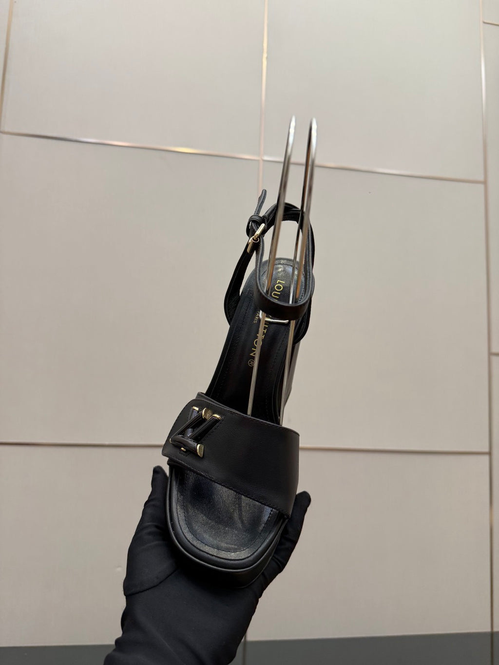 Women’s black platform heeled sandal shown from side/back with ankle strap and buckle.