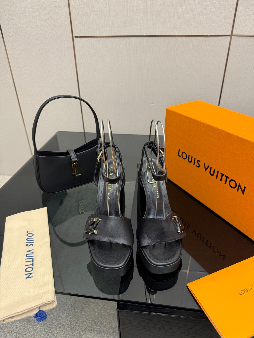 Women’s platform heeled sandals in dark leather with ankle strap and V buckle.