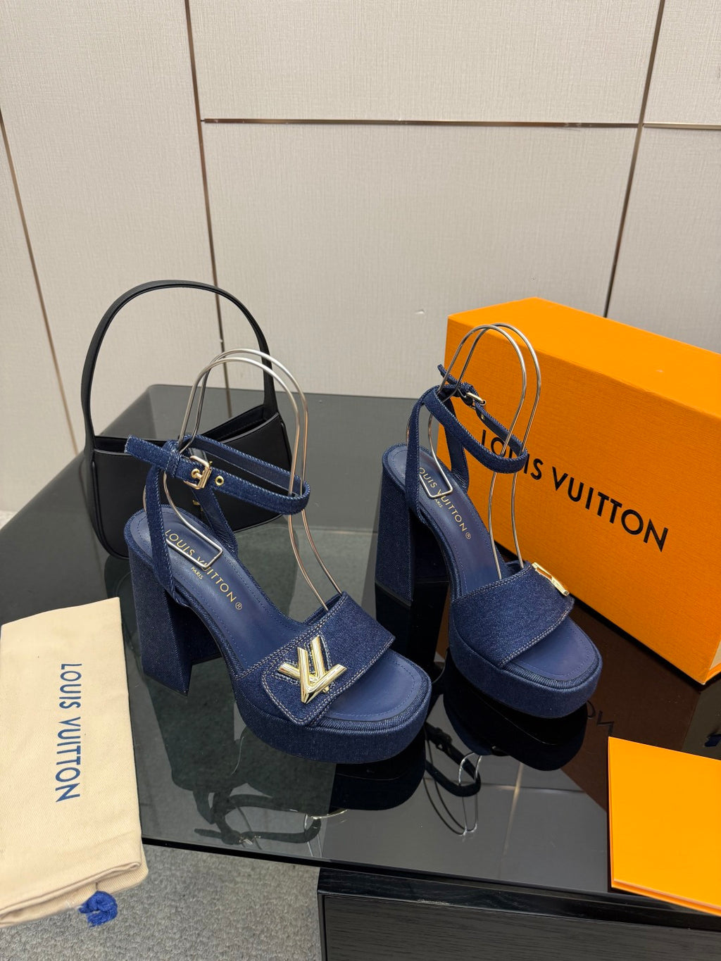 Pair of blue platform heeled sandals with gold logo accents and ankle strap