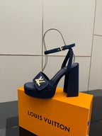Blue platform heeled sandal with gold logo buckle and wide high heel