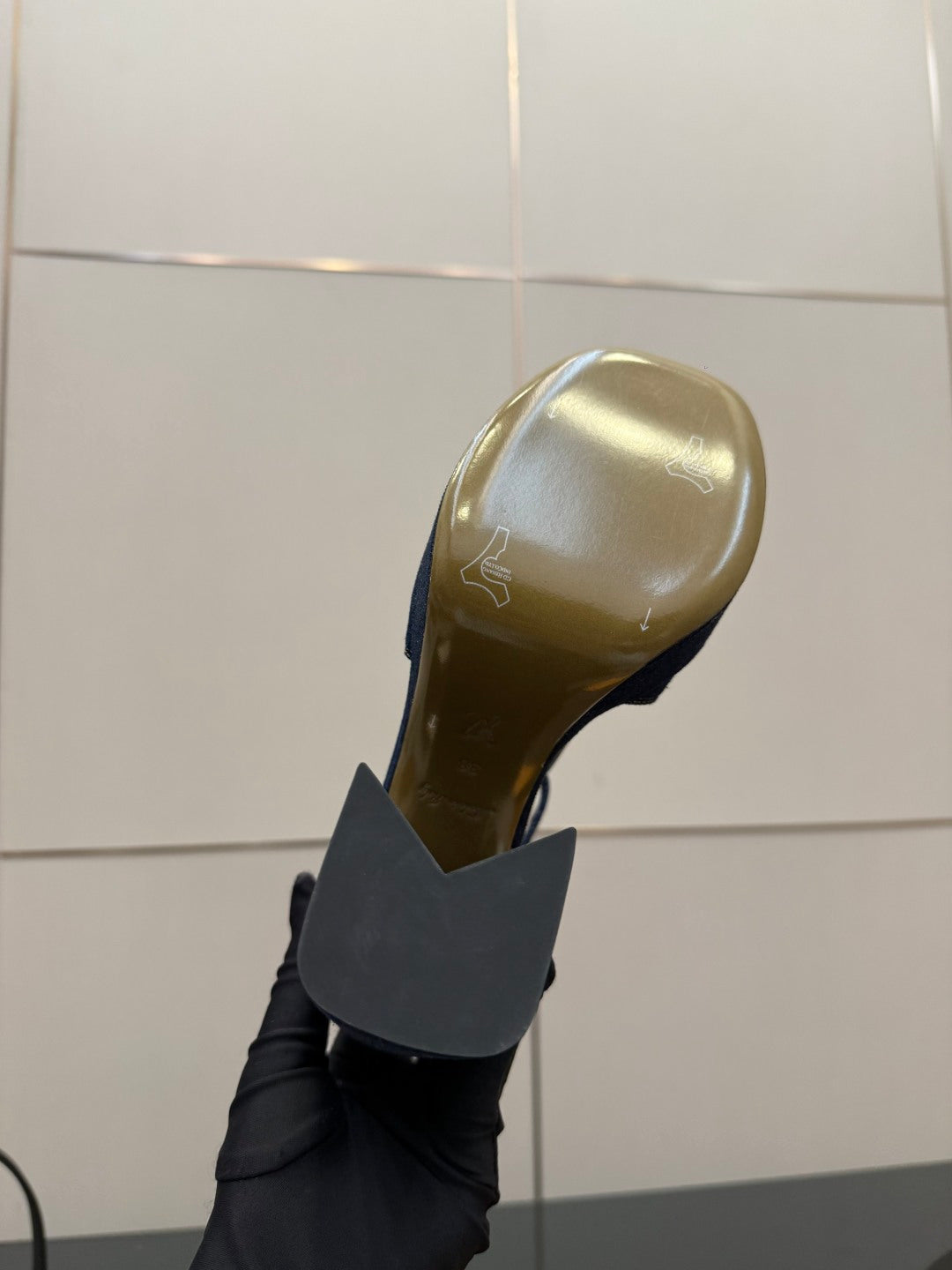 Black platform heel sole viewed from side, with inner gold logo stamp