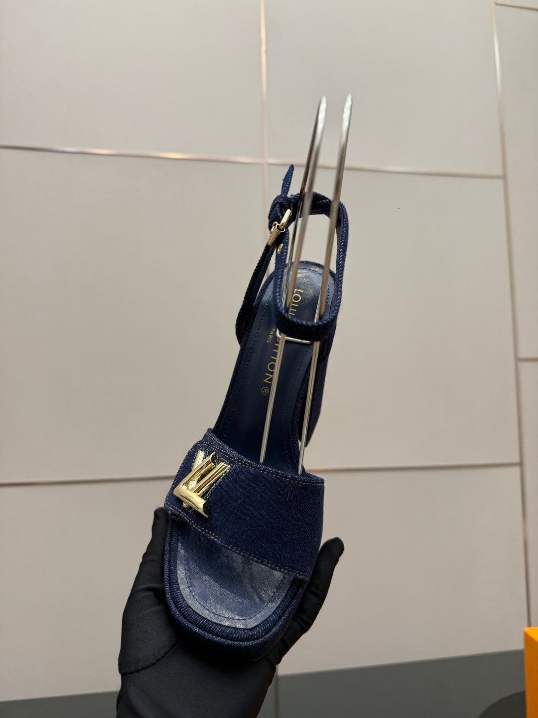 Blue suede platform heeled sandal with gold logo emblem and ankle strap