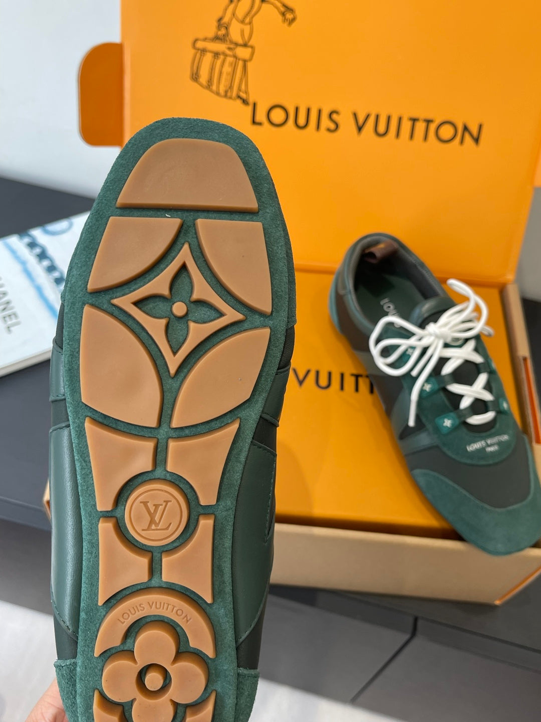 Teal lace-up sneaker outsole with tan floral-style LV logo tread pattern