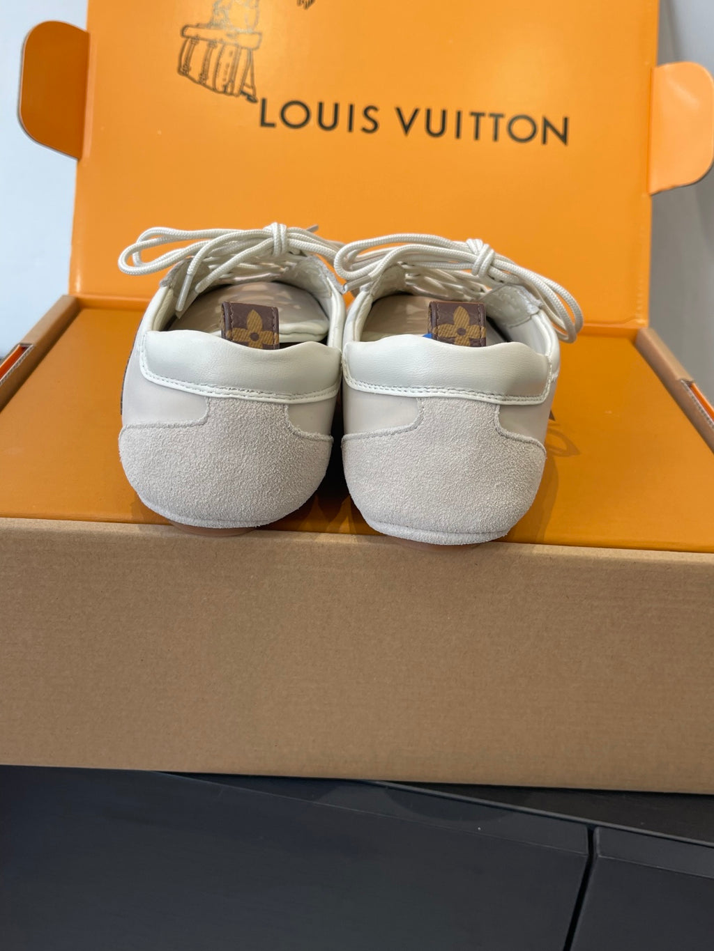 Louis Vuitton sneakers back view, light beige canvas uppers with tied white laces
