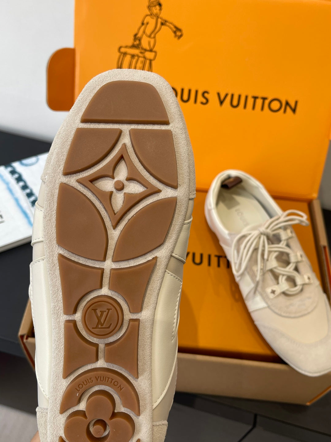 Beige Louis Vuitton unisex sneakers, close-up of patterned rubber outsole with LV marks