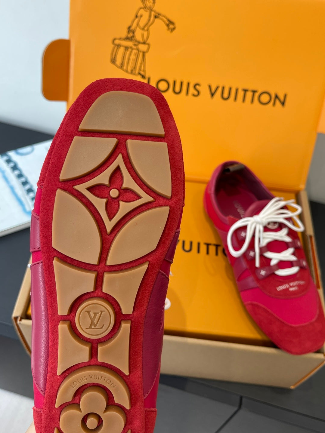 Louis Vuitton unisex red sneaker sole with tan graphic, white laces visible
