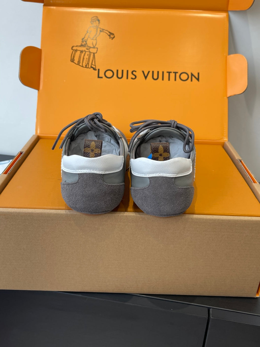Gray Louis Vuitton lace-up sneakers with rear view and small logo patch, pair shown